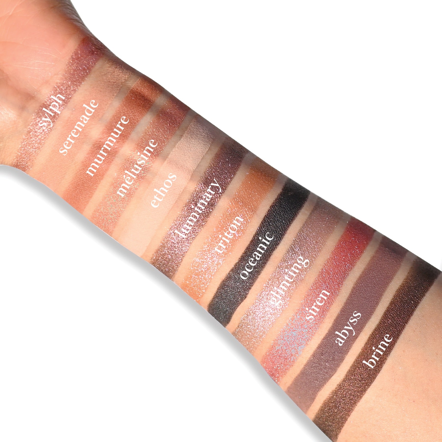 Swatches of Sireneuse Étendu on fair skin, displaying champagne rose, greige, violet-blue, and soft nude shades.