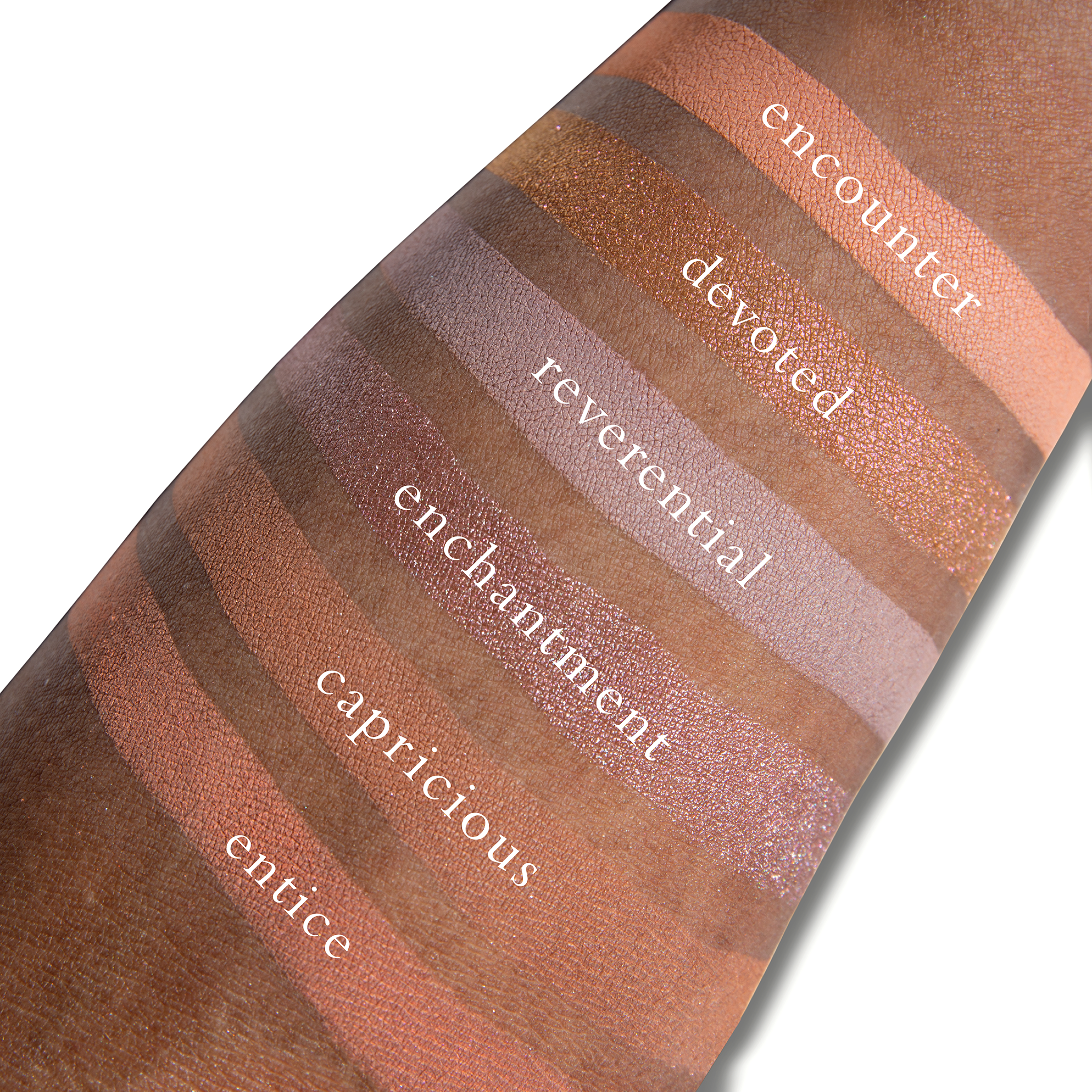 Swatches of Fleurette Coeur on deep skin with pastel lilac, soft shimmer pinks, and cool-toned highlights for a diffused glow.