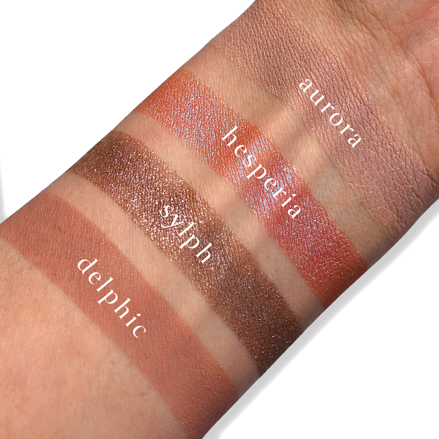 Swatches of eyeshadow powders from the Petits Fours - Hesperides palette on fair skin, showcasing timeless rose, mauve, and nude hues.