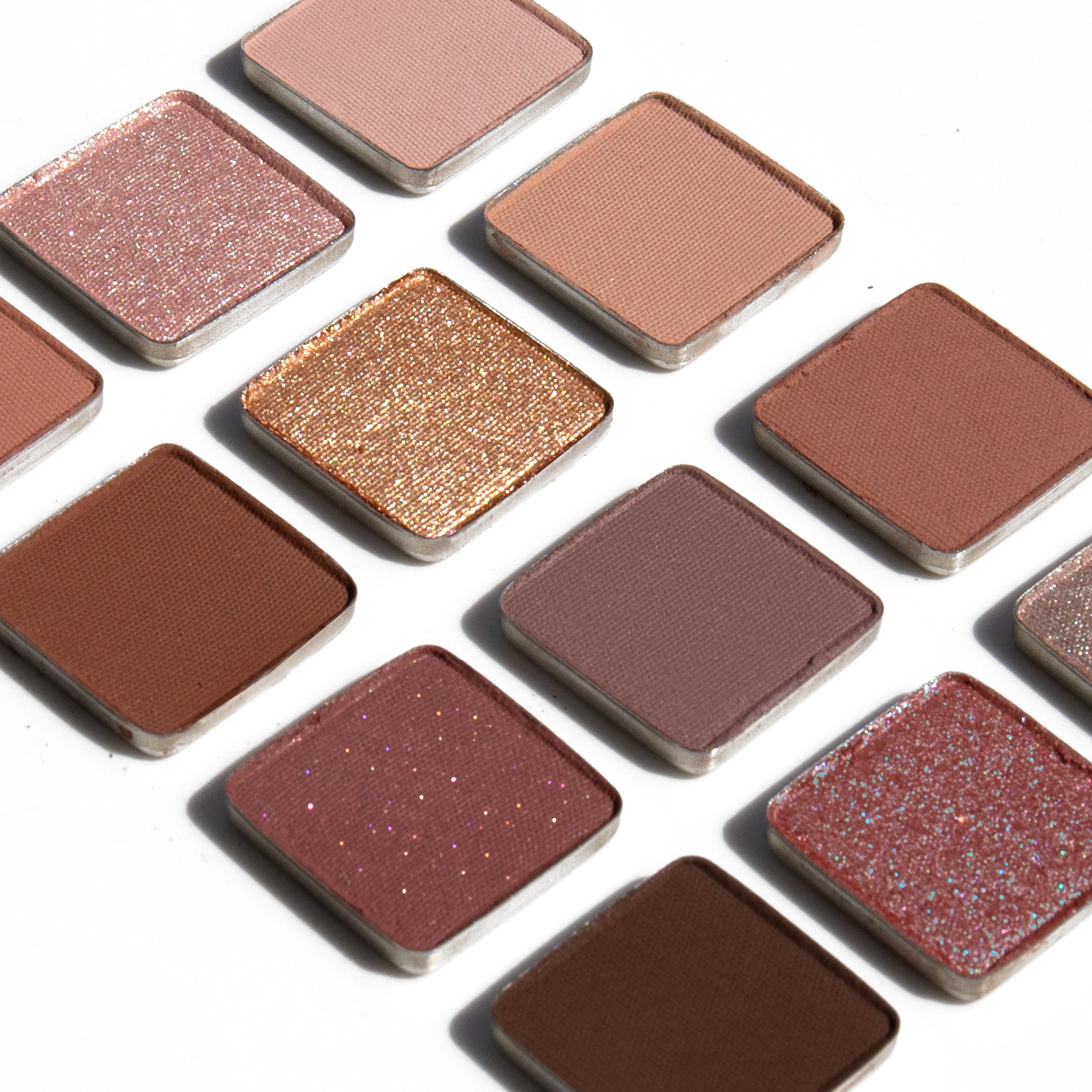Swatches of Midsommer Lumière Étendu eyeshadow palette with spring cool rose, shimmering taupes, nude browns, and rosewood hues.