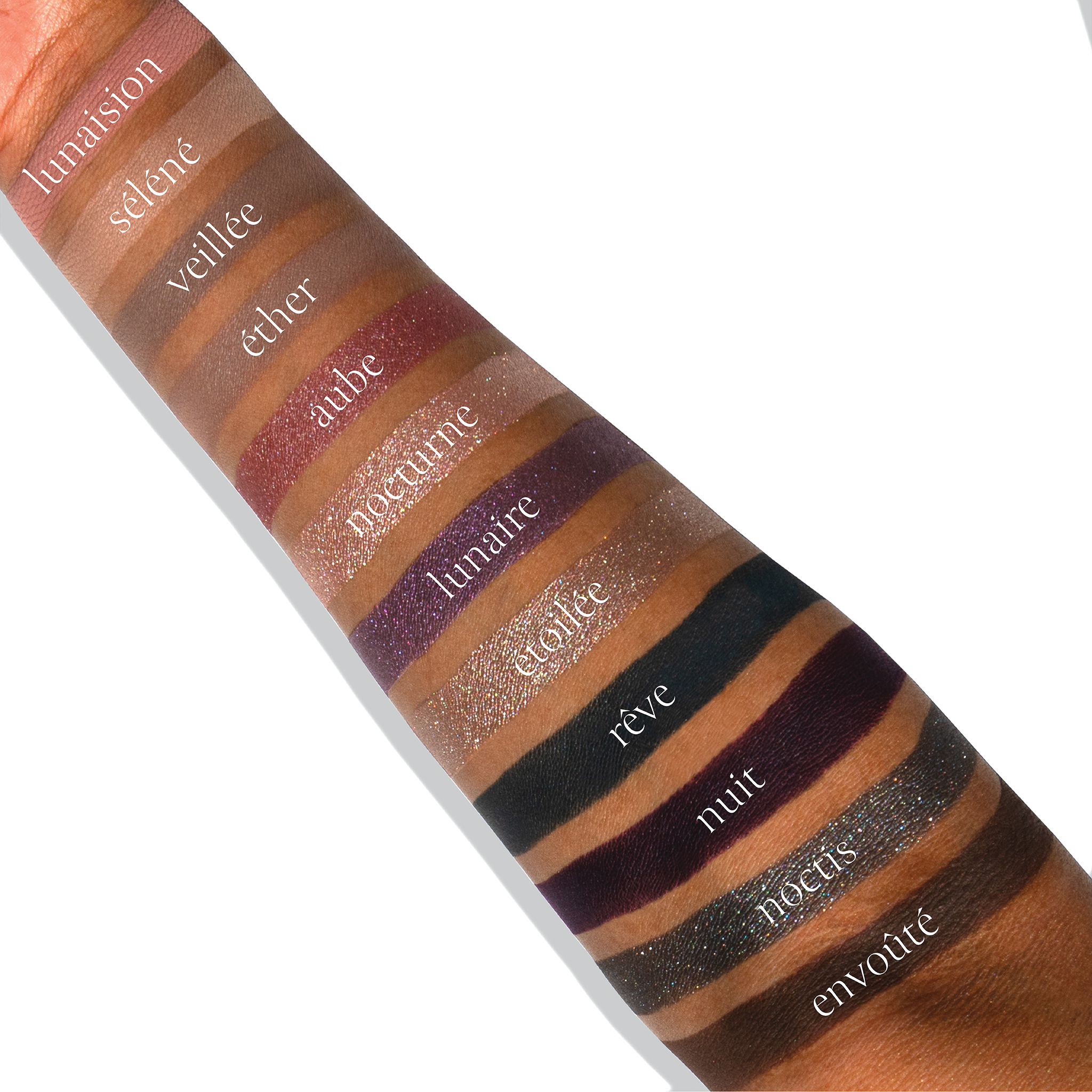 Swatches of PARIS NUIT ÉTENDU tones on deep skin, including nuit and aube hues for sculpting and blending.
