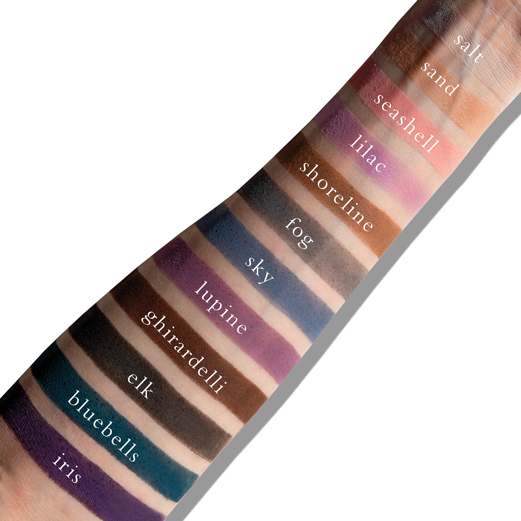 Swatches of cool matte tones like slate and mauve on fair skin, showing soft contrast and dimension.