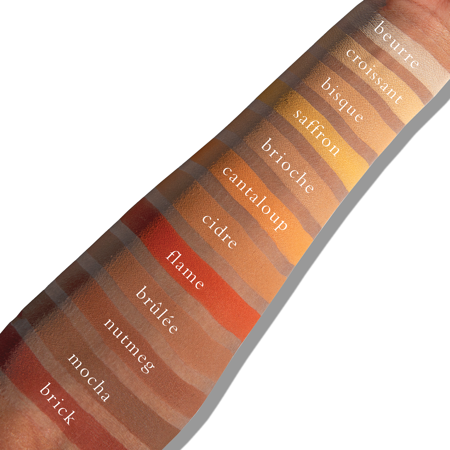 Swatches of warm matte tones like sienna and umber on deep skin, providing bold sculpt and radiant warmth.