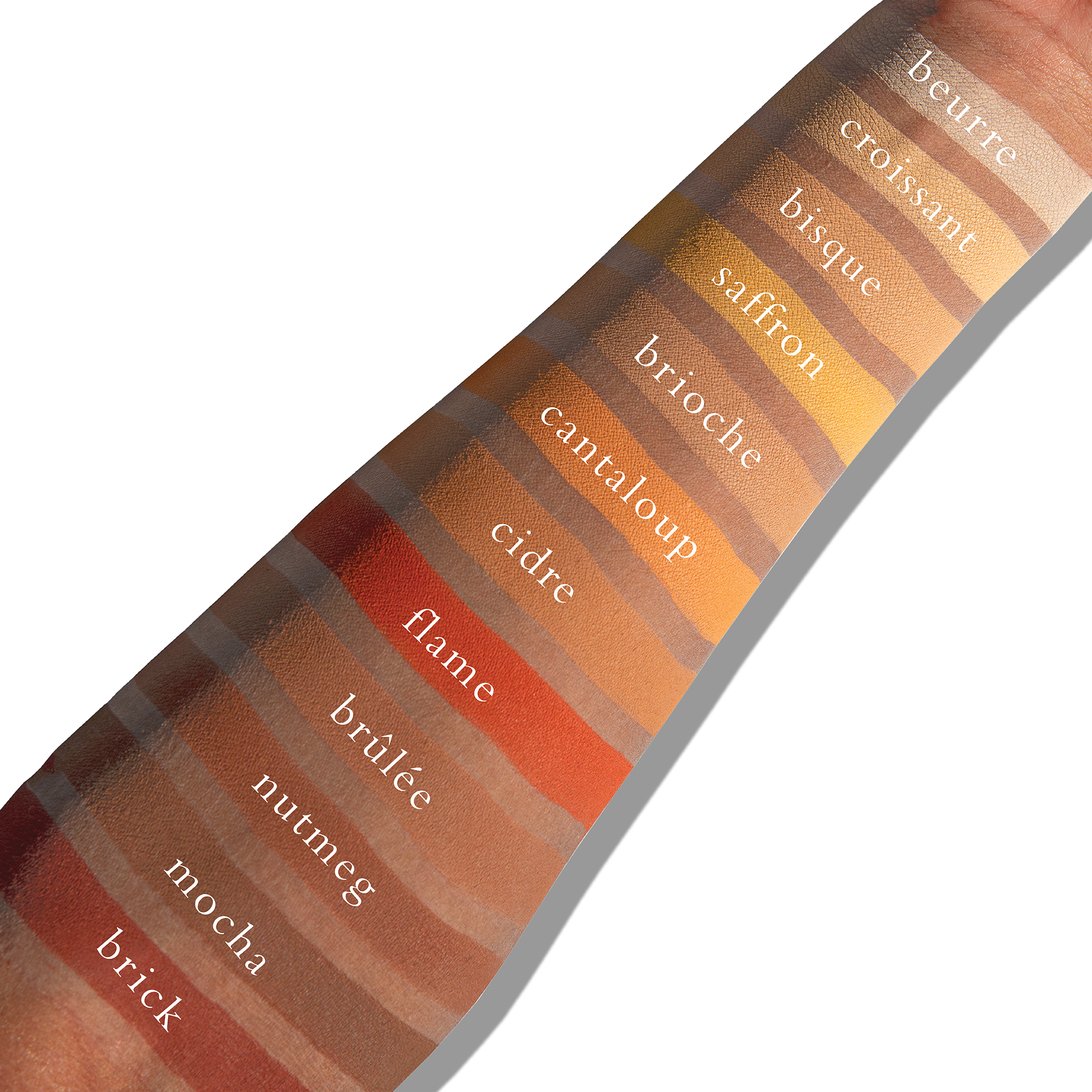 Swatches of warm matte tones like sienna and umber on deep skin, providing bold sculpt and radiant warmth.