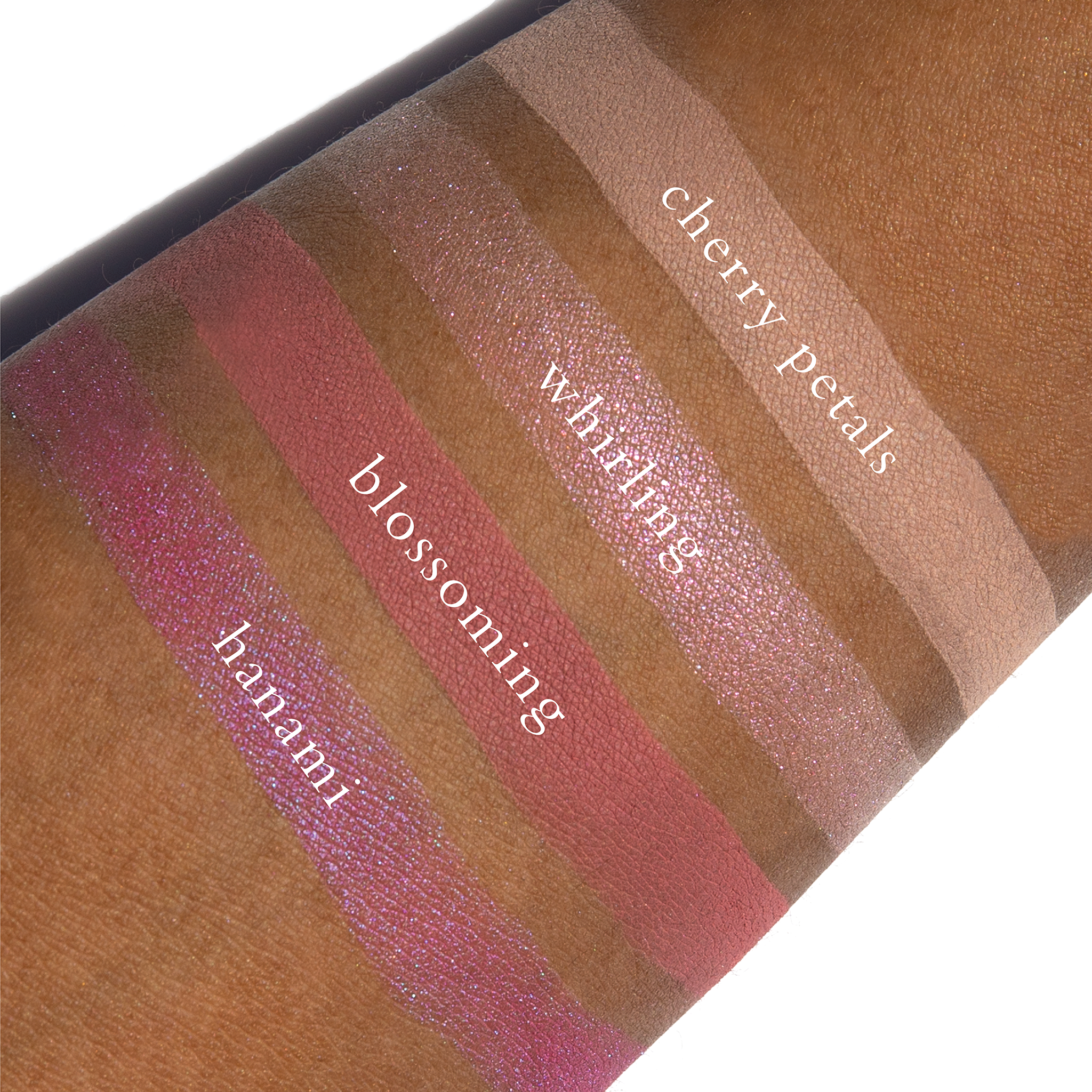 Swatches of sakura pink, light rose, and soft shimmer from Sakura Lotus on deep skin tone.