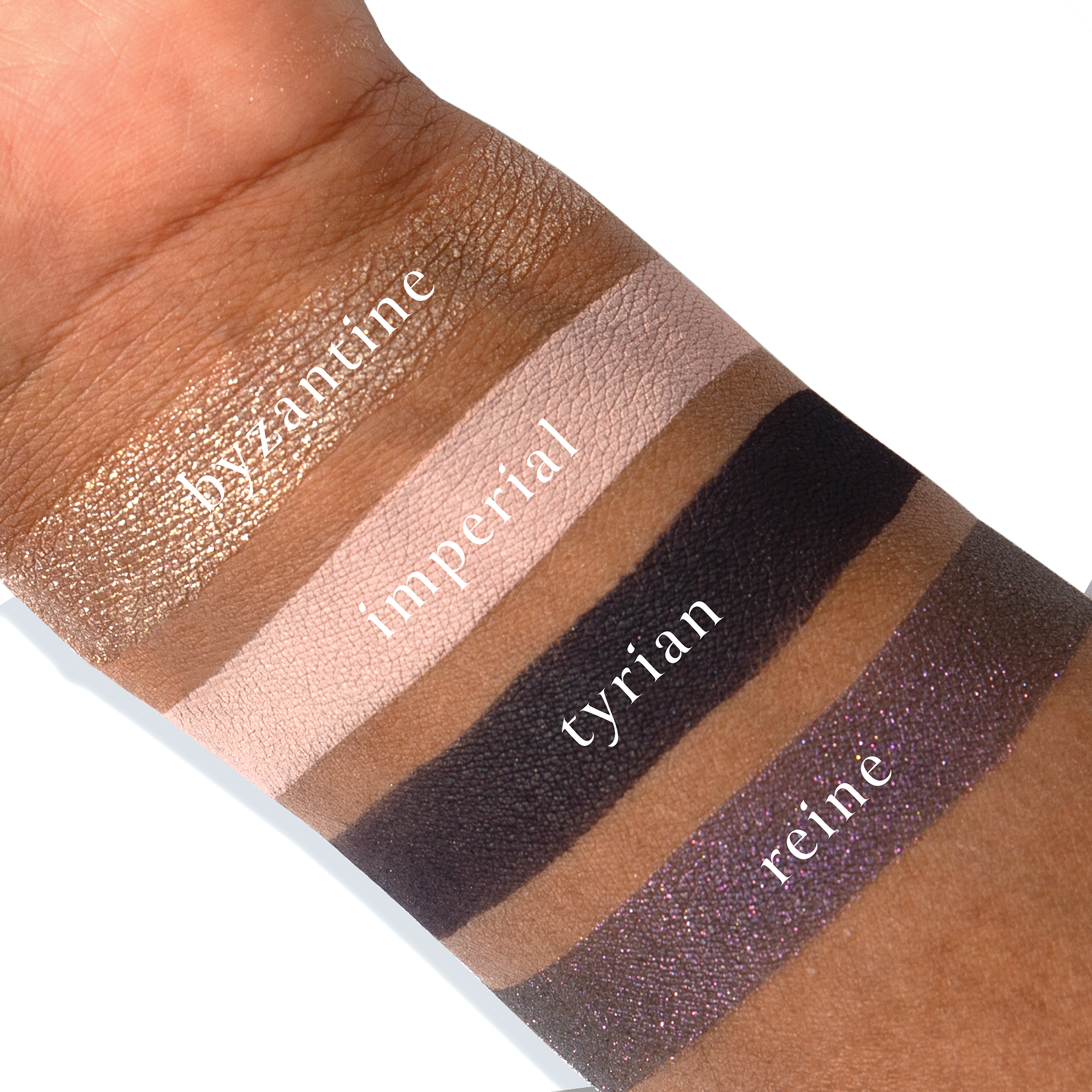 Swatches of Petits Fours Tyrian on deep skin, displaying amethyst foil, soft plum, and deep wine tones.
