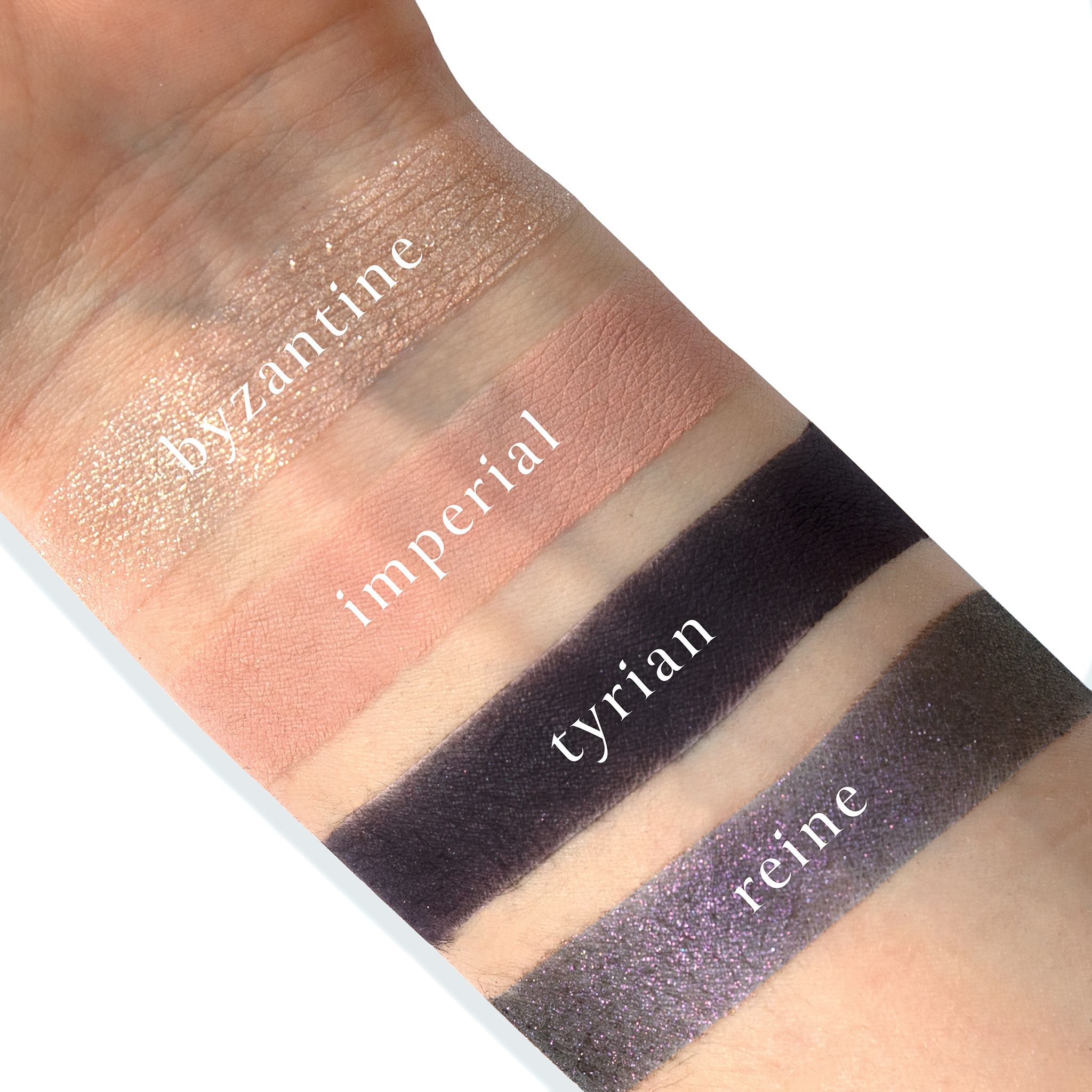 Swatches of Petits Fours Tyrian on fair skin, featuring plum matte, burgundy foil, and fig shimmer.