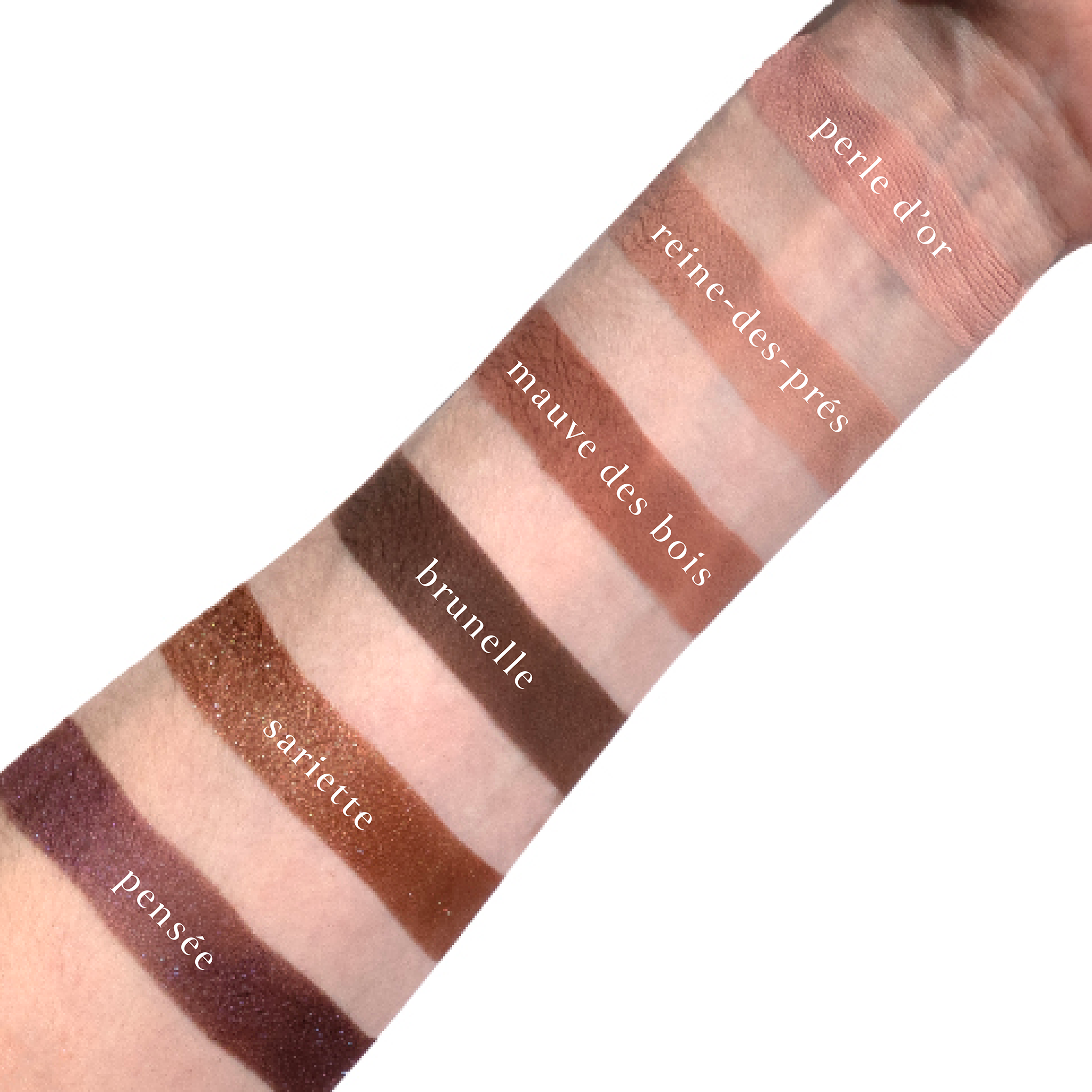 Swatches of Violette Vespertine on fair skin featuring plum matte, icy lilac shimmer, and mauve neutrals.