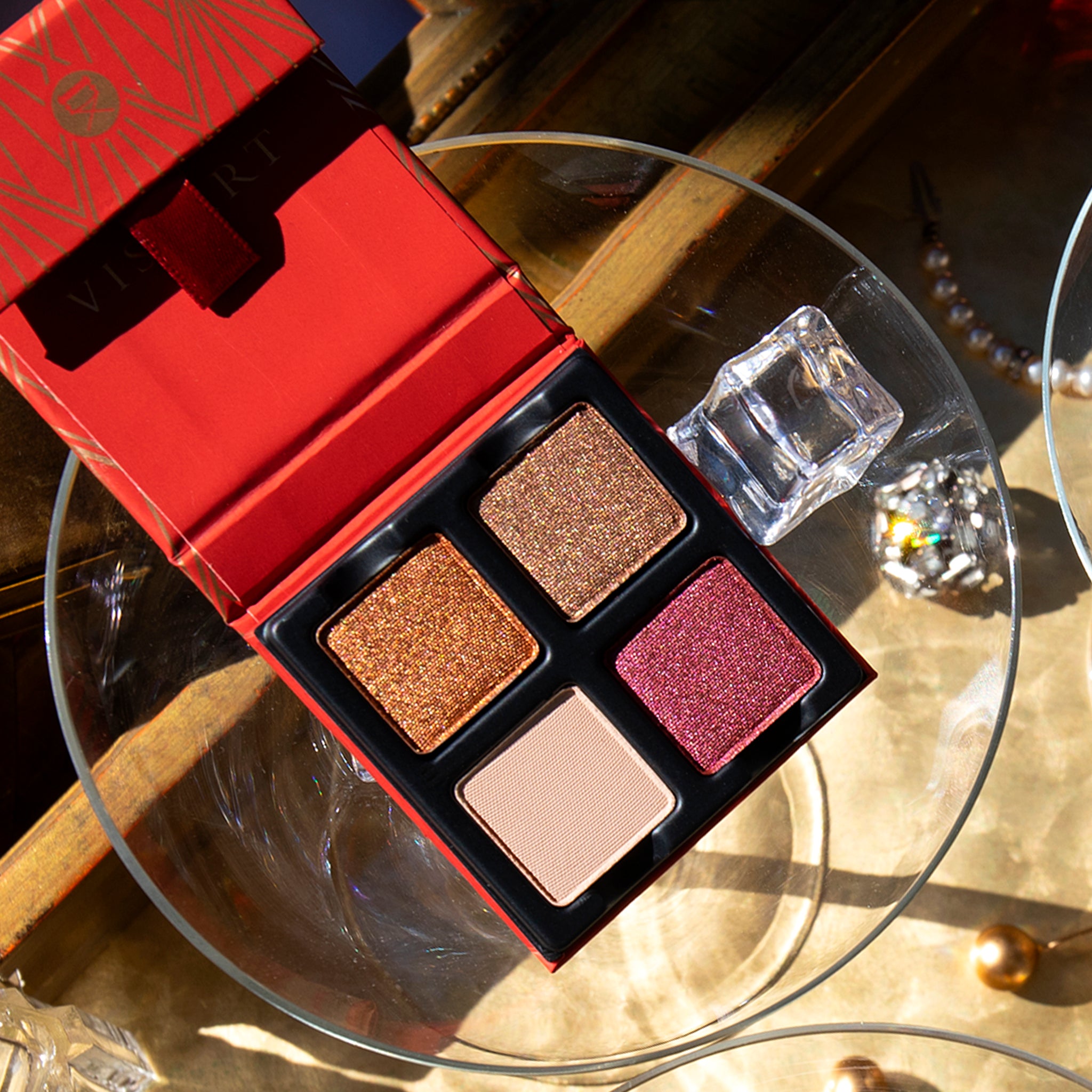 Opened Petits Fours Garnet palette with garnet shimmer, plum satin, and wine-toned matte shadows.
