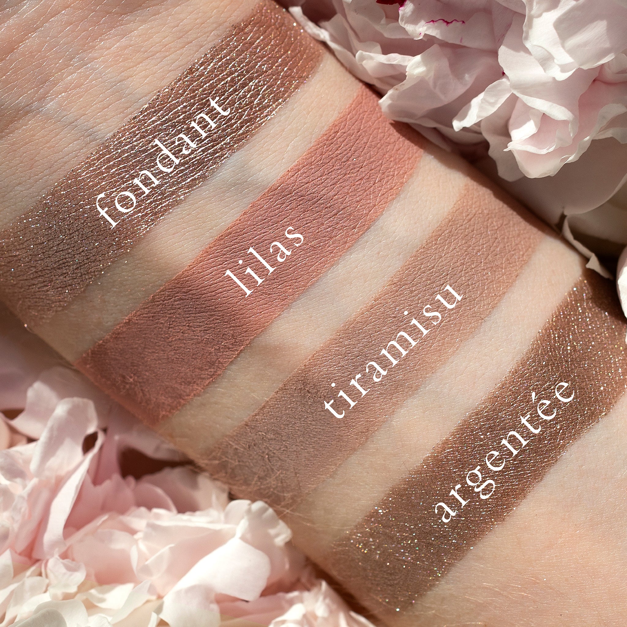 Swatches of Petits Fours Lilas on fair skin, showing pastel lilac, mauve shimmer, and soft plum tones.