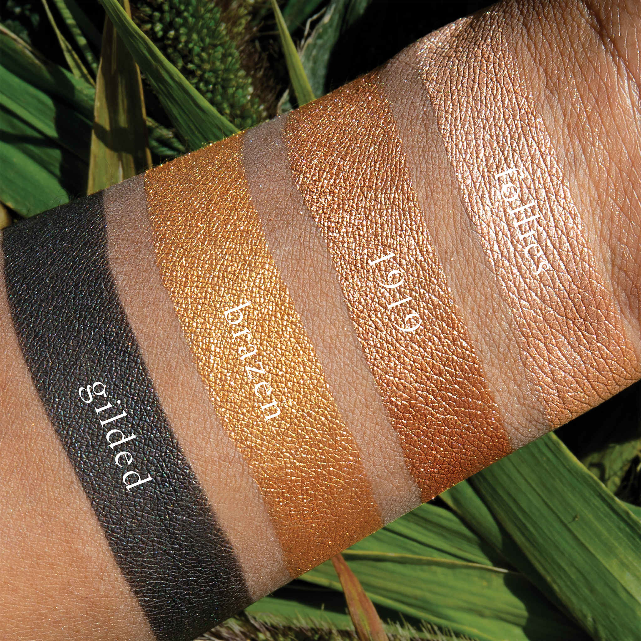 Swatches of Petits Fours Bullion on deep skin, with bold gold, light metallic shimmer, and deep matte black.