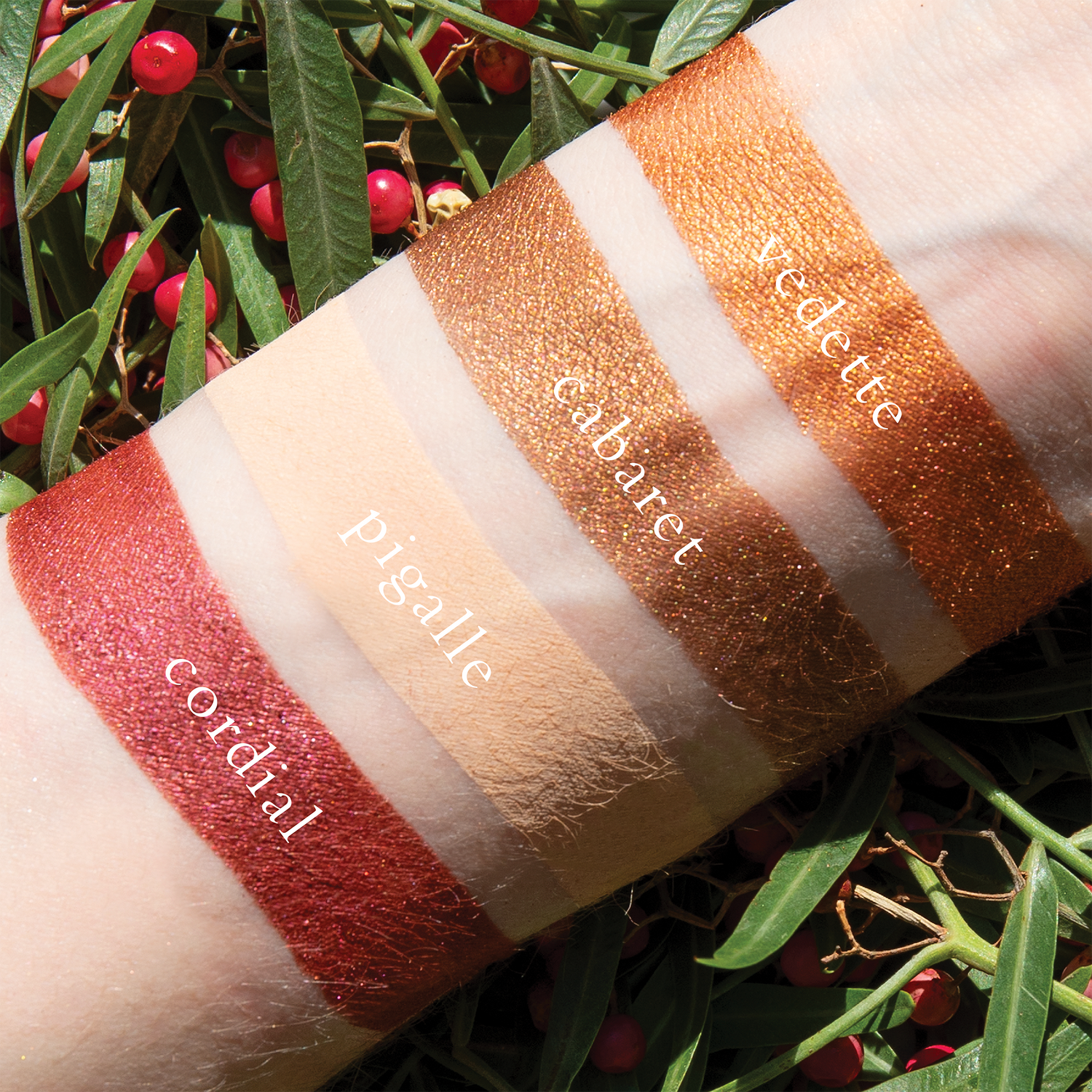 Swatches of Petits Fours Garnet on fair skin, featuring deep garnet shimmer, burgundy matte, and plum tones.