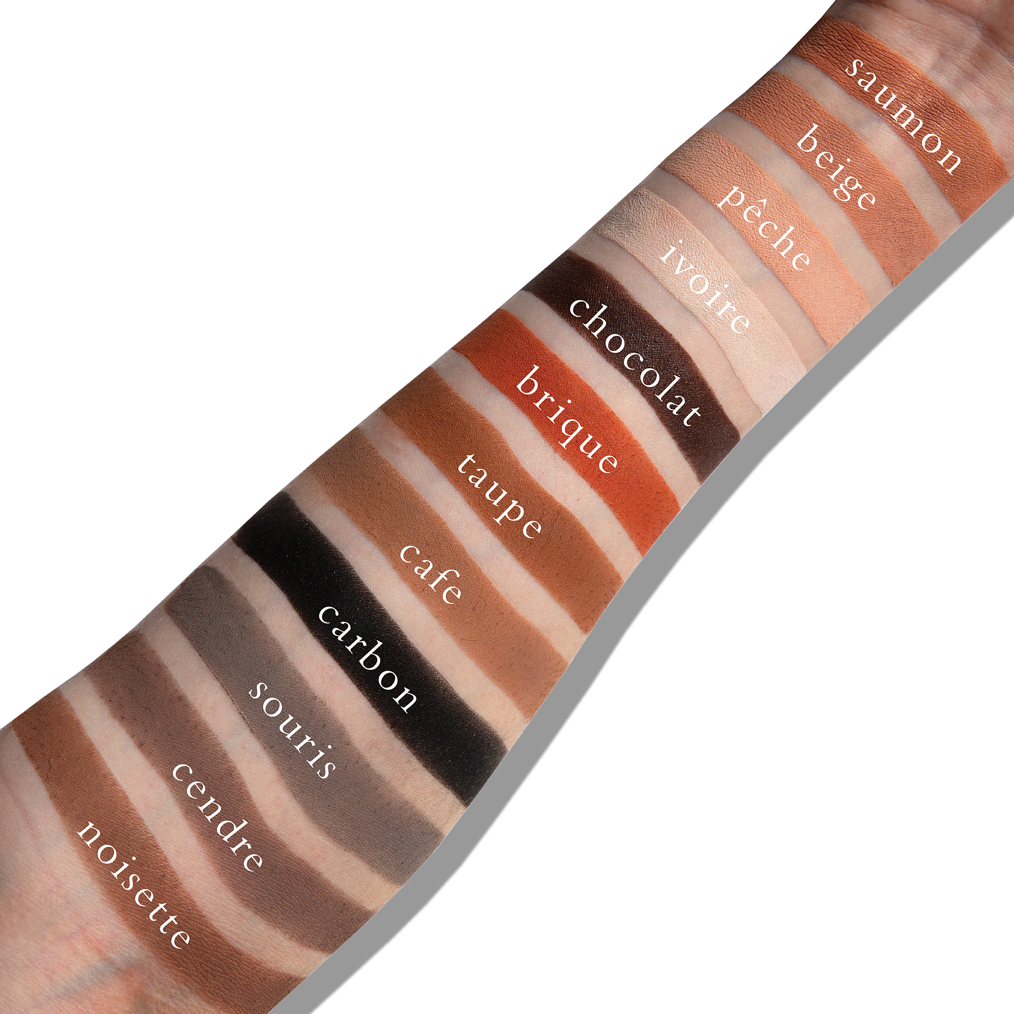 Swatches of matte neutrals like taupe and brown on fair skin, showing blendable, sculpting pigments.