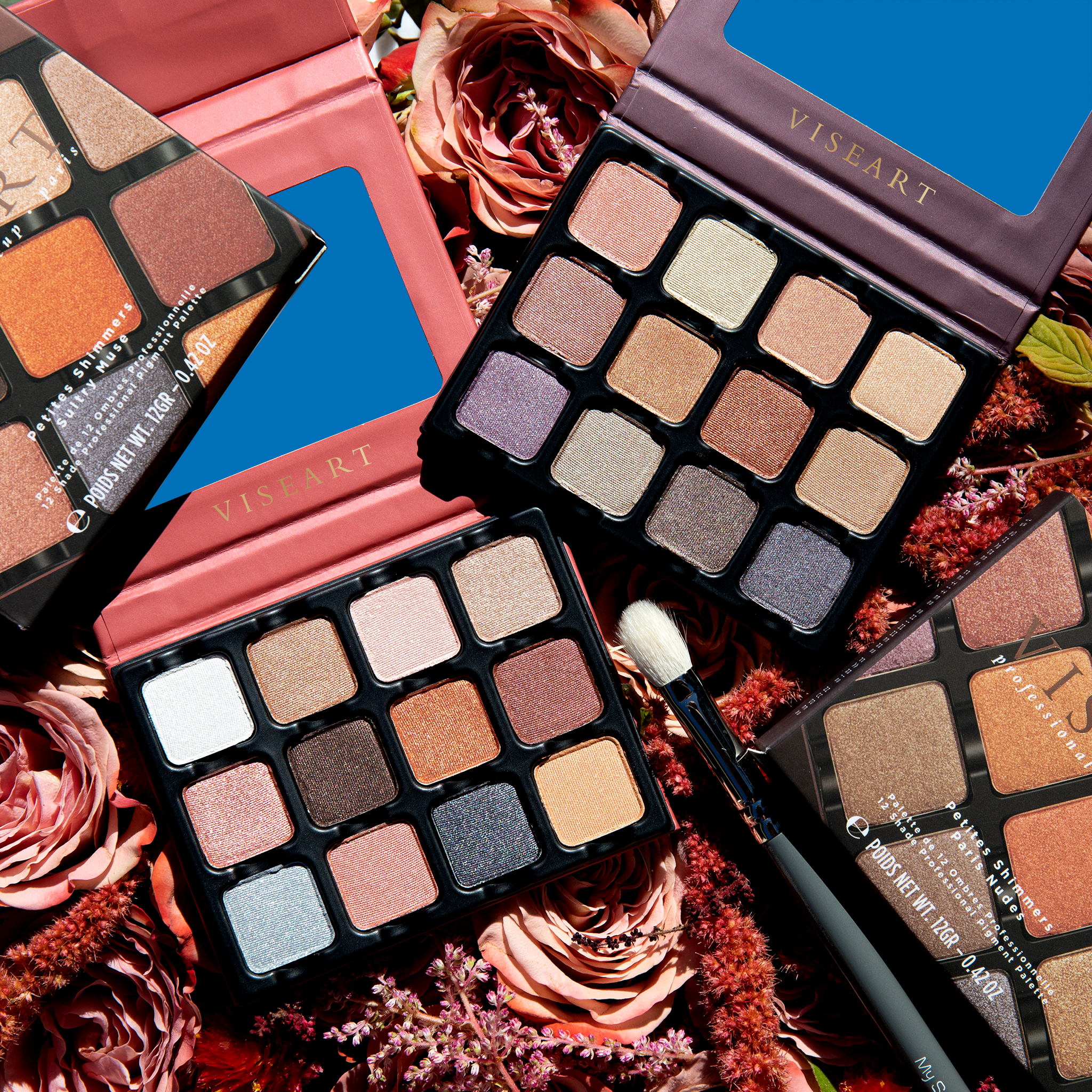 Open Petities Shimmers Sultry Muse 12-pan palette showcasing a warm array of pressed powders, grouped with one open Petites Shimmers Sultry Paris Nudes palette and one Petite Shimmers Sultry muse palette in the original packaging.