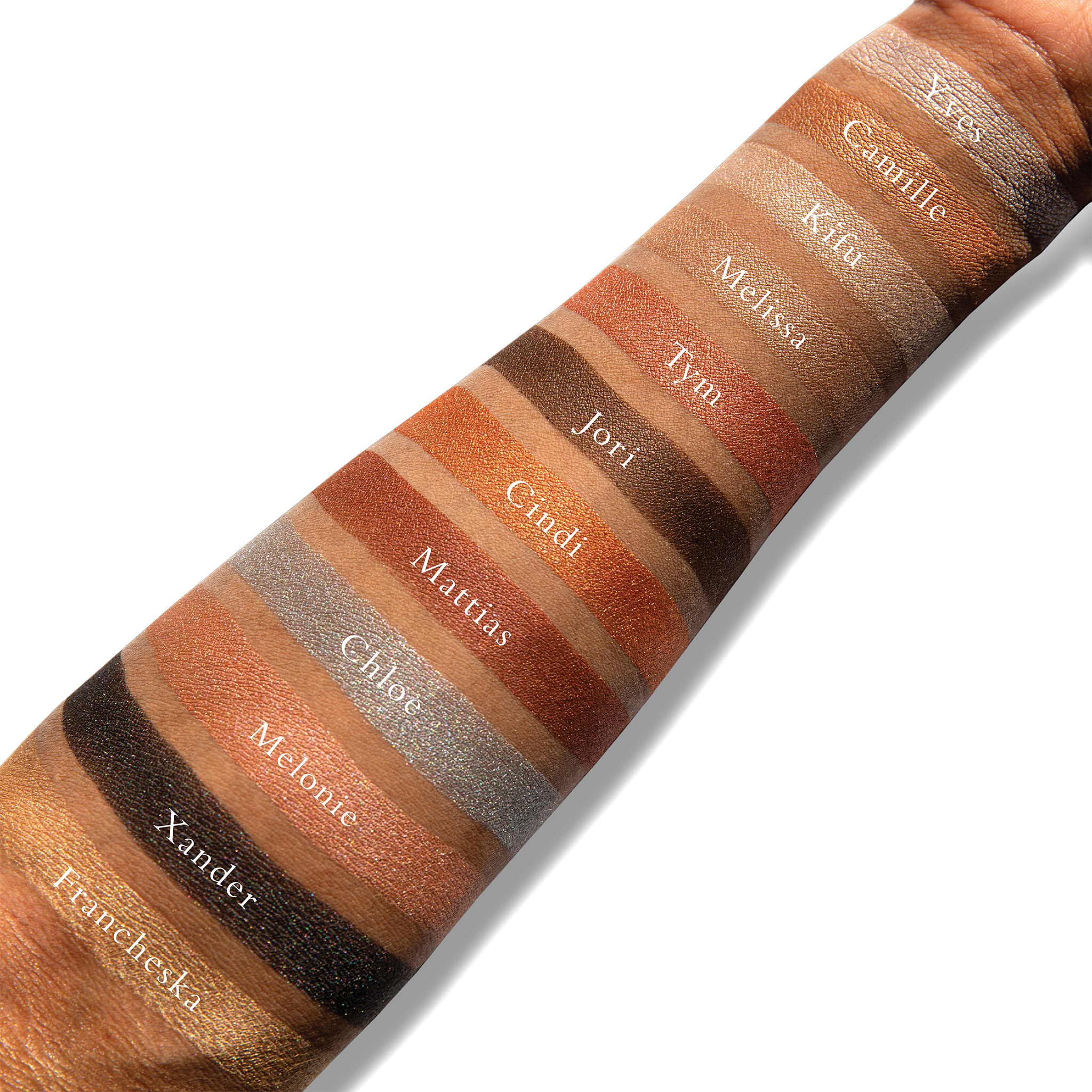 Swatches of powders from the Petites Shimmers Sultry Muse palette on deep skin, showcasing versatile tones for highlighting and defining the face.