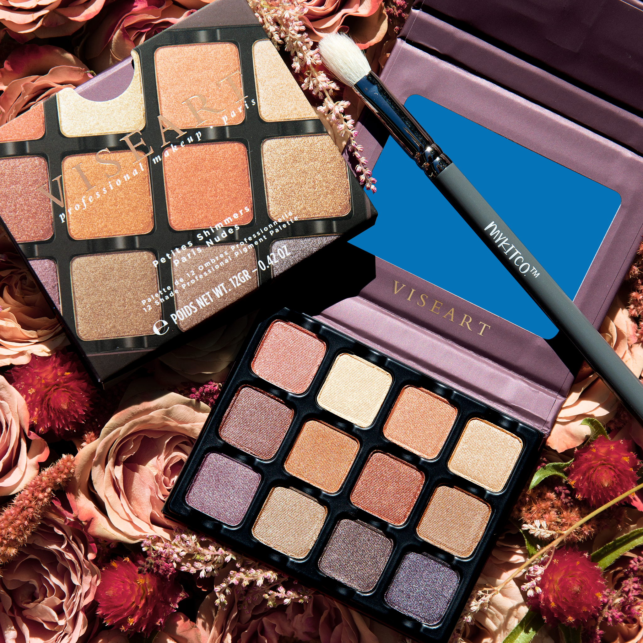 Open Petities Shimmers Paris Nudes 12-pan palette grouped with a closed Petites Shimmers Paris Nudes palette and a makeup brush, showcasing nude, peach, rose, and plum shades.