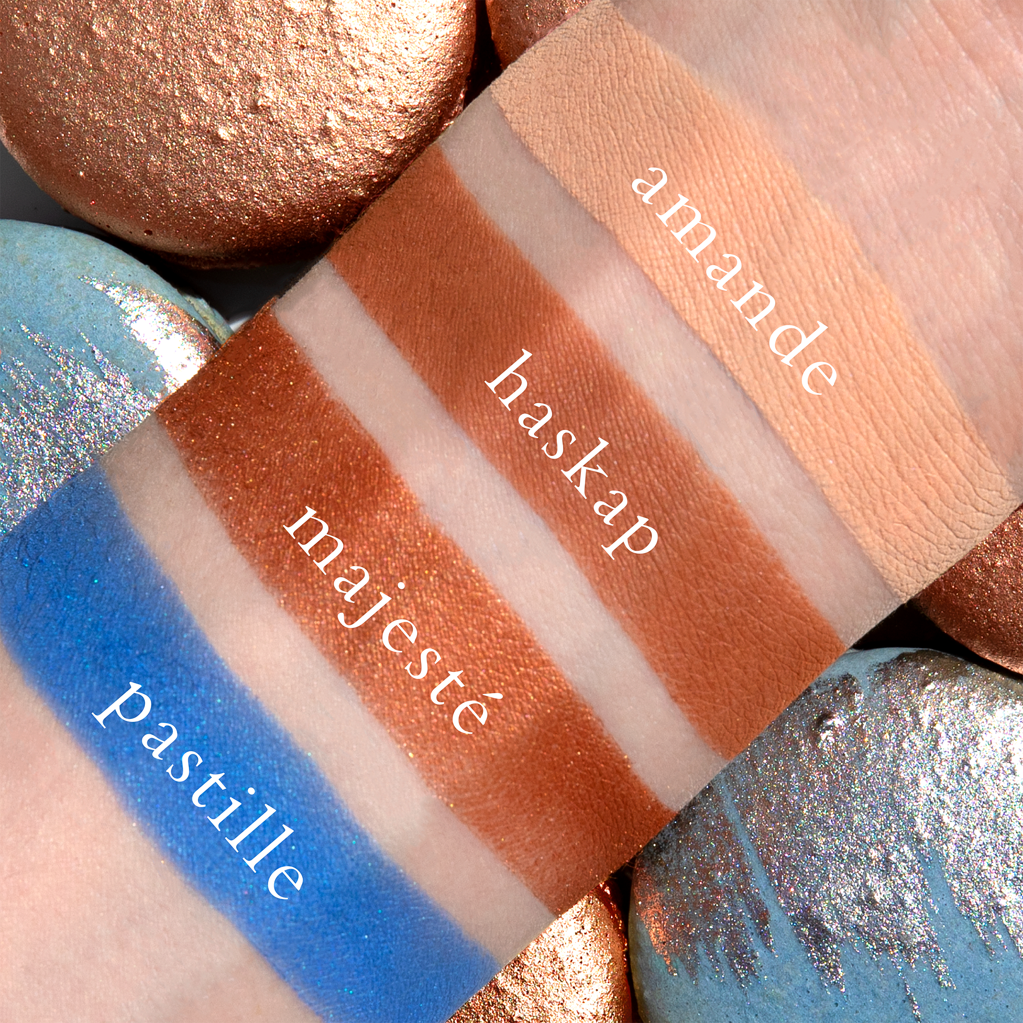 Swatches of Petits Fours Pastille on fair skin, displaying cream matte, cobalt shimmer, and rich brown.