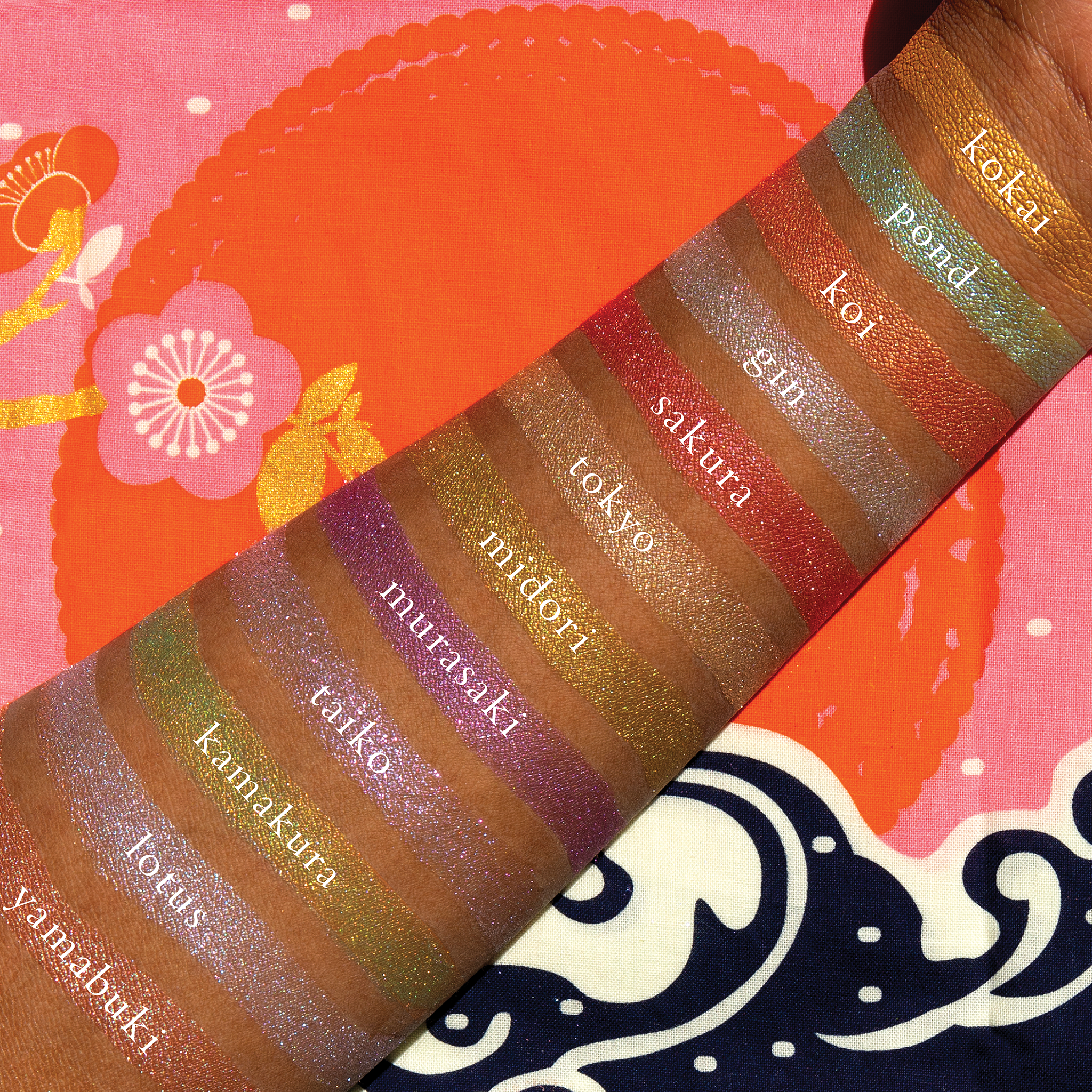 Swatches of lilac, rose gold, and icy lavender duochrome shimmer shades from Petites Shimmers Coy on deep skin tone.