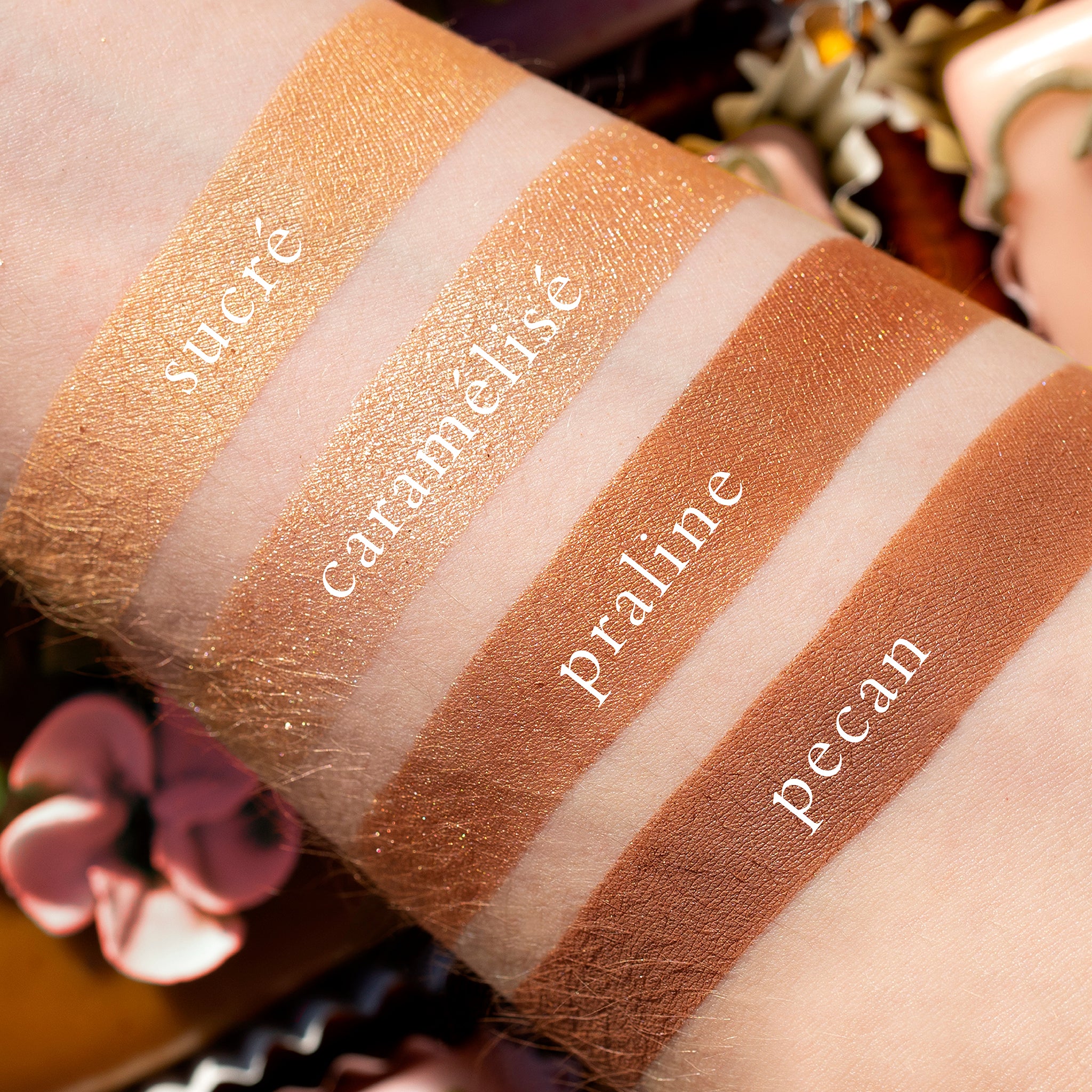 Swatches of Petits Fours Praline on fair skin, featuring warm taupe, champagne gold, and latte shimmer.