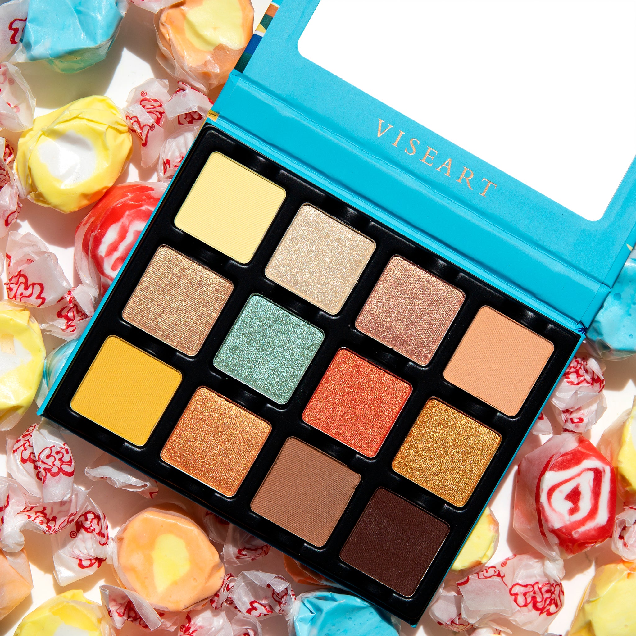 Open palette of vibrant beach tones including coral shimmer, sunbeam gold, and bronze foil for summer glam.