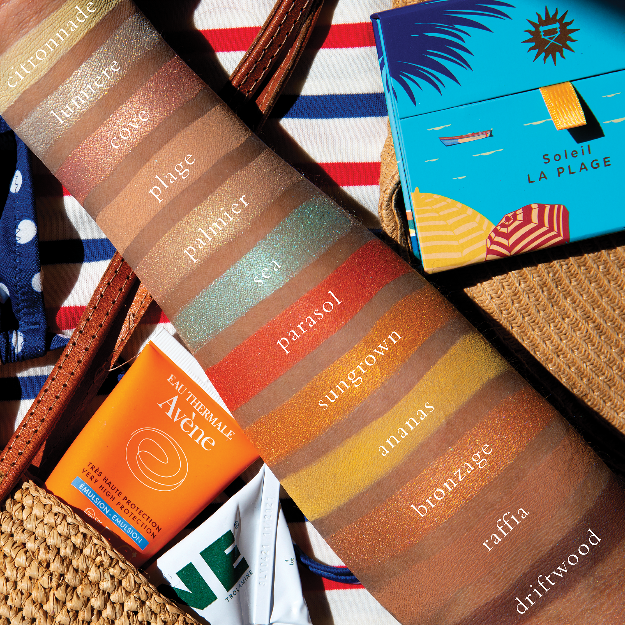 Swatches on deep skin of bronzed shimmer, peach coral, and tropical tones for radiant sun-kissed looks.
